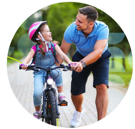 Father teaching daughter to ride her bike